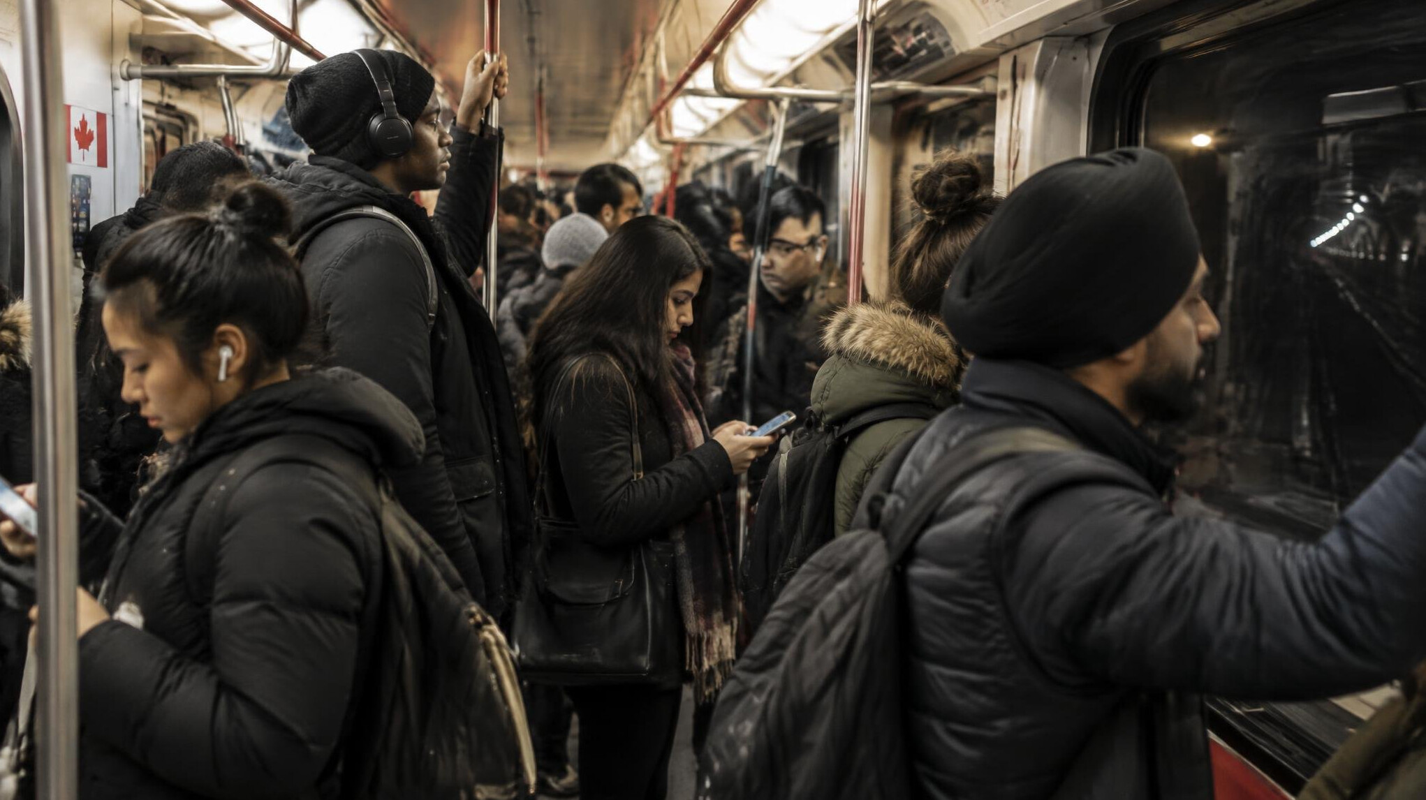 Commuters standing inside a city subway car during rush hour