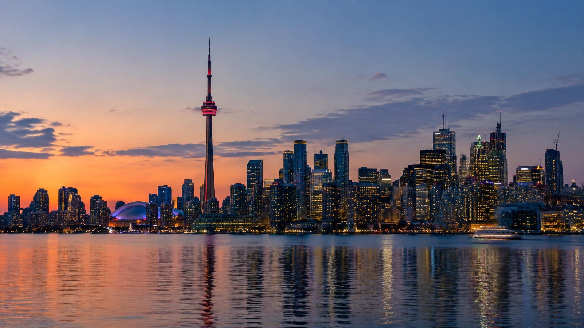 City skyline silhouette at dusk with lights turning on in office towers